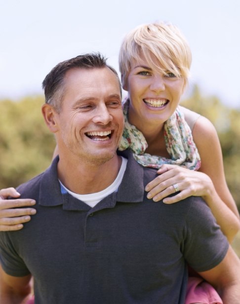 Man and woman with healthy smiles after periodontal therapy