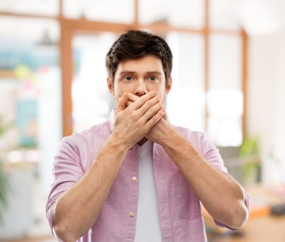 Man covering his mouth during periodontal emergency
