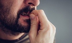 closeup of man biting his fingernails 