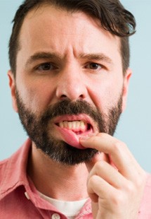 man pointing to inflamed gums 