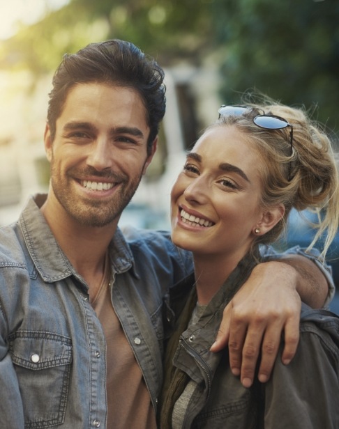 Man and woman with healthy smiles after periodontal therapy
