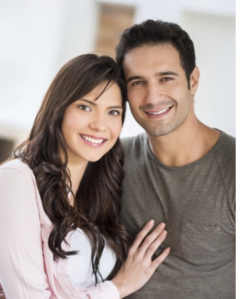 Man and woman with healthy smiles after surgical periodontal treatment