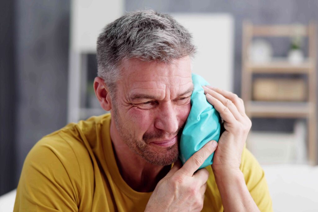 Man with an ice pack on his cheek